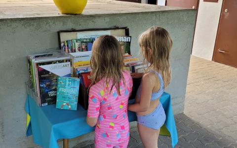 Kinder beim Bücherkoffer im Freibad
